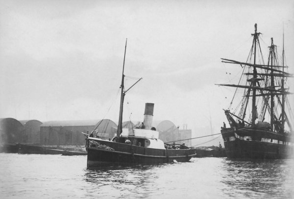 Schleppdampfer mit Großsegler vor den Surrey Docks, London